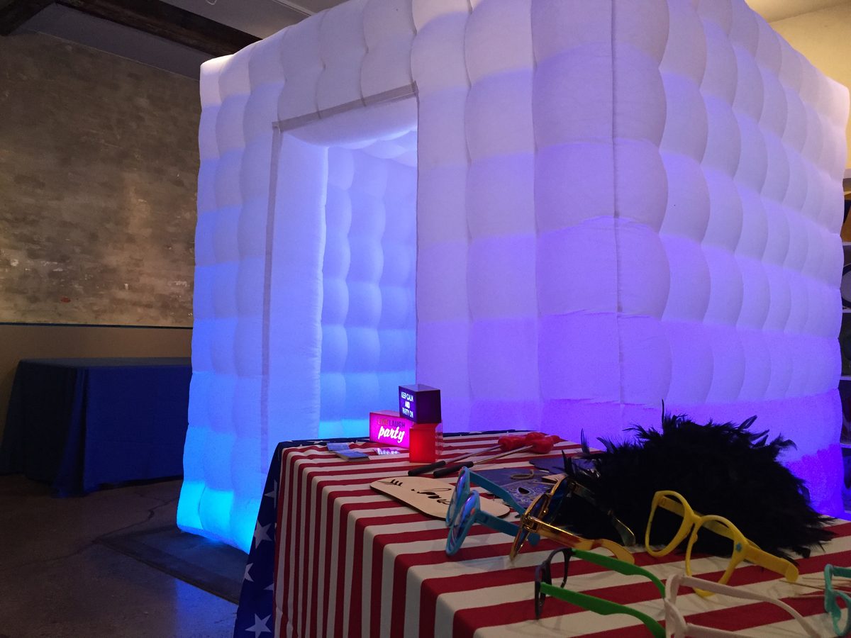 LED inflatable photo booth with a table of fun props